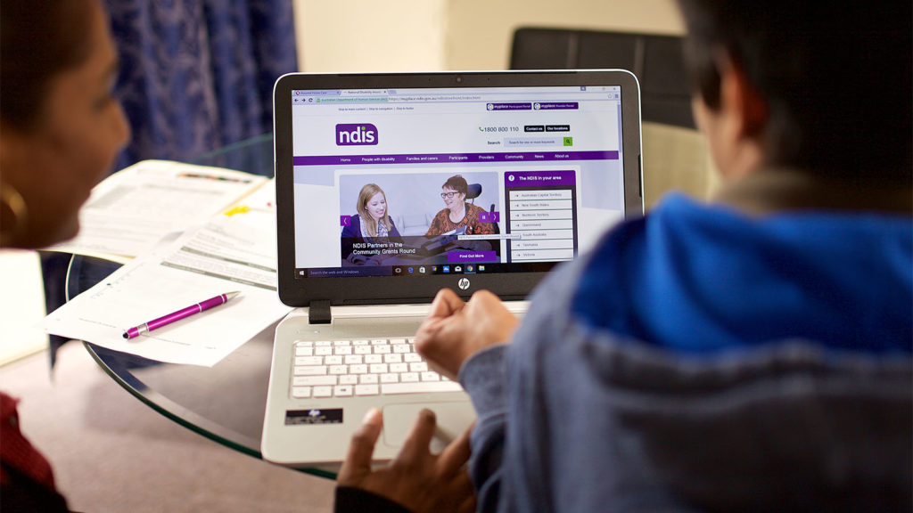 carer and client using laptop